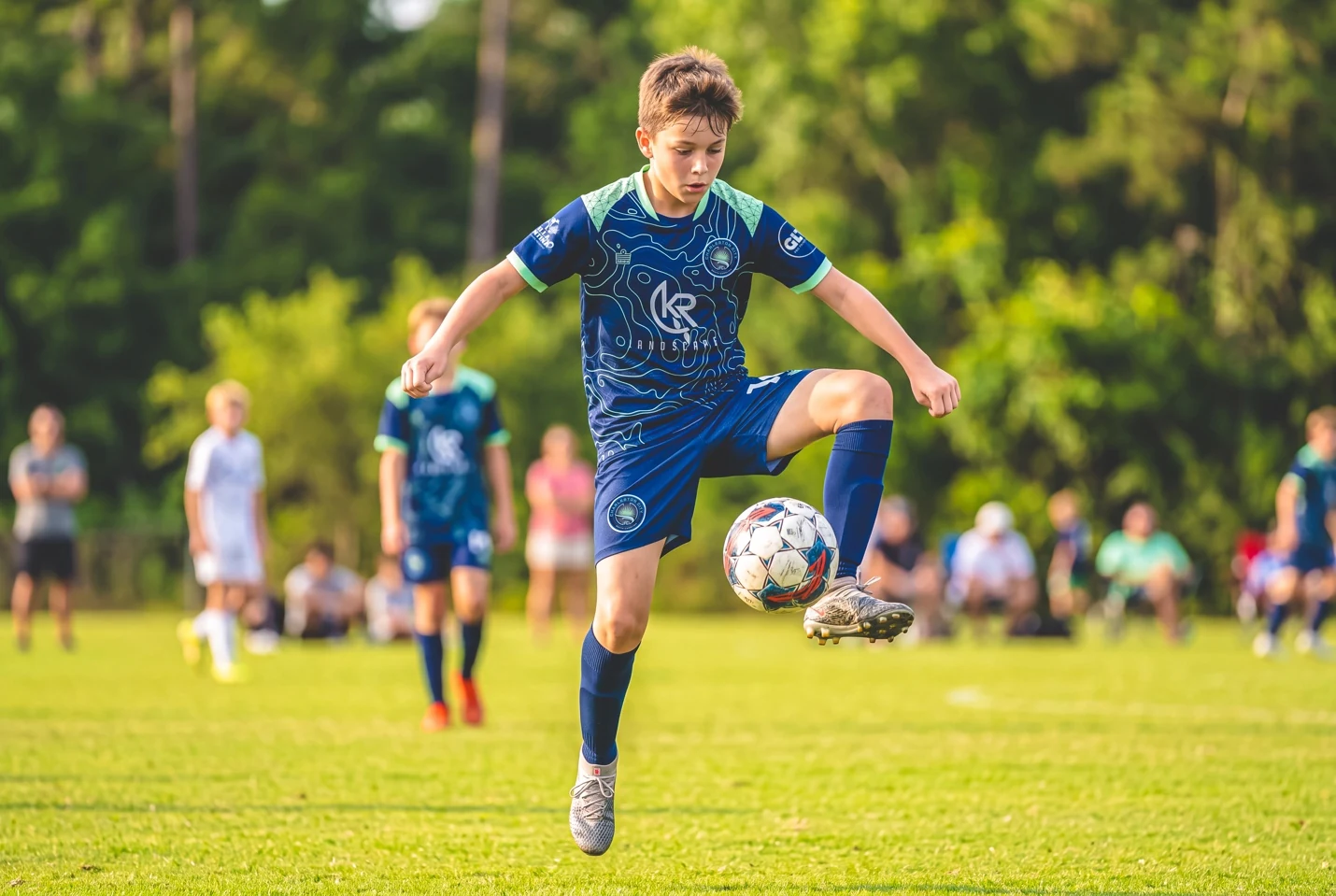 Girls navy and teal away kit in match action